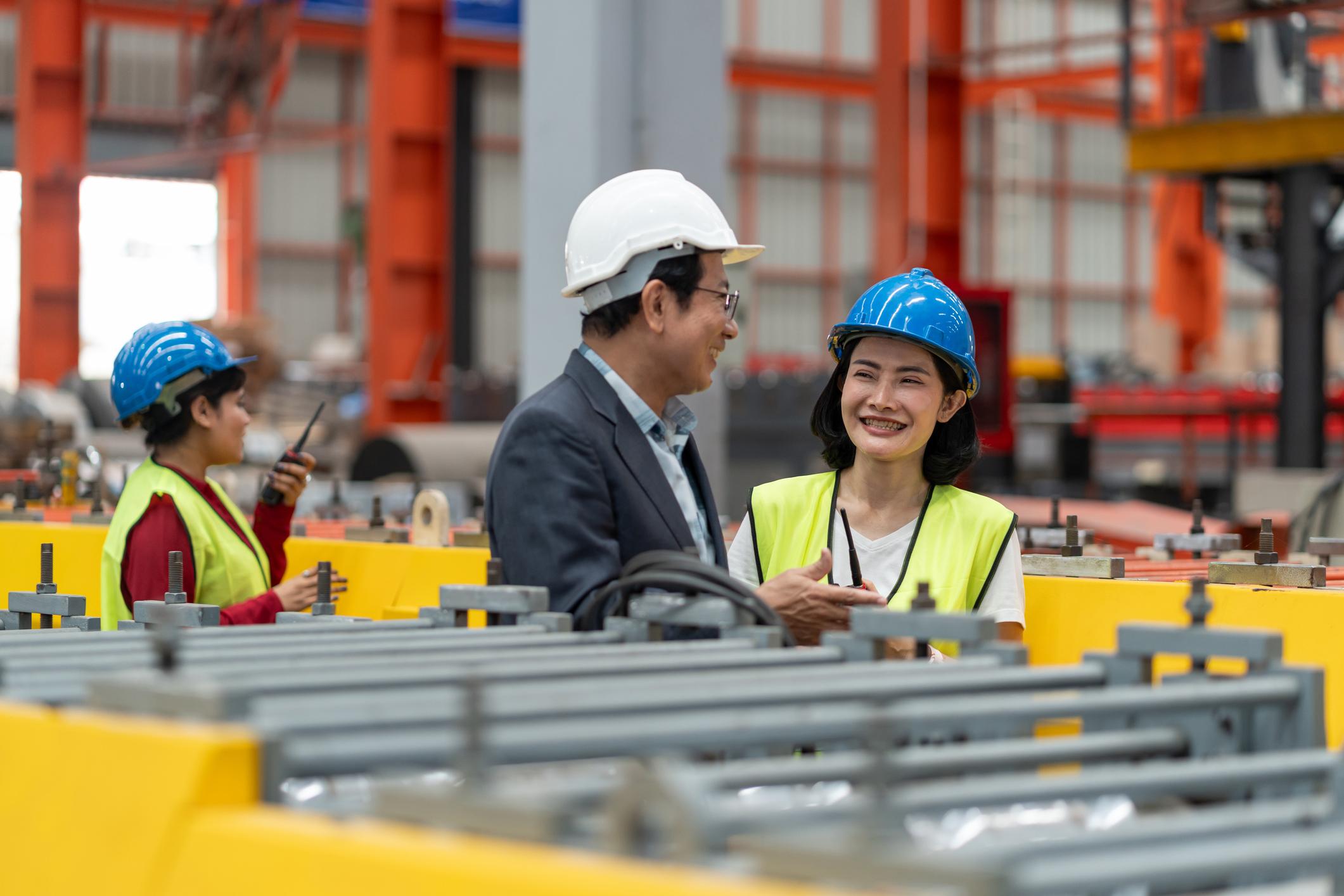 Engineers discussing their work together in an industrial workshop